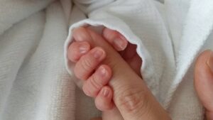 赤ちゃんの手とママの指